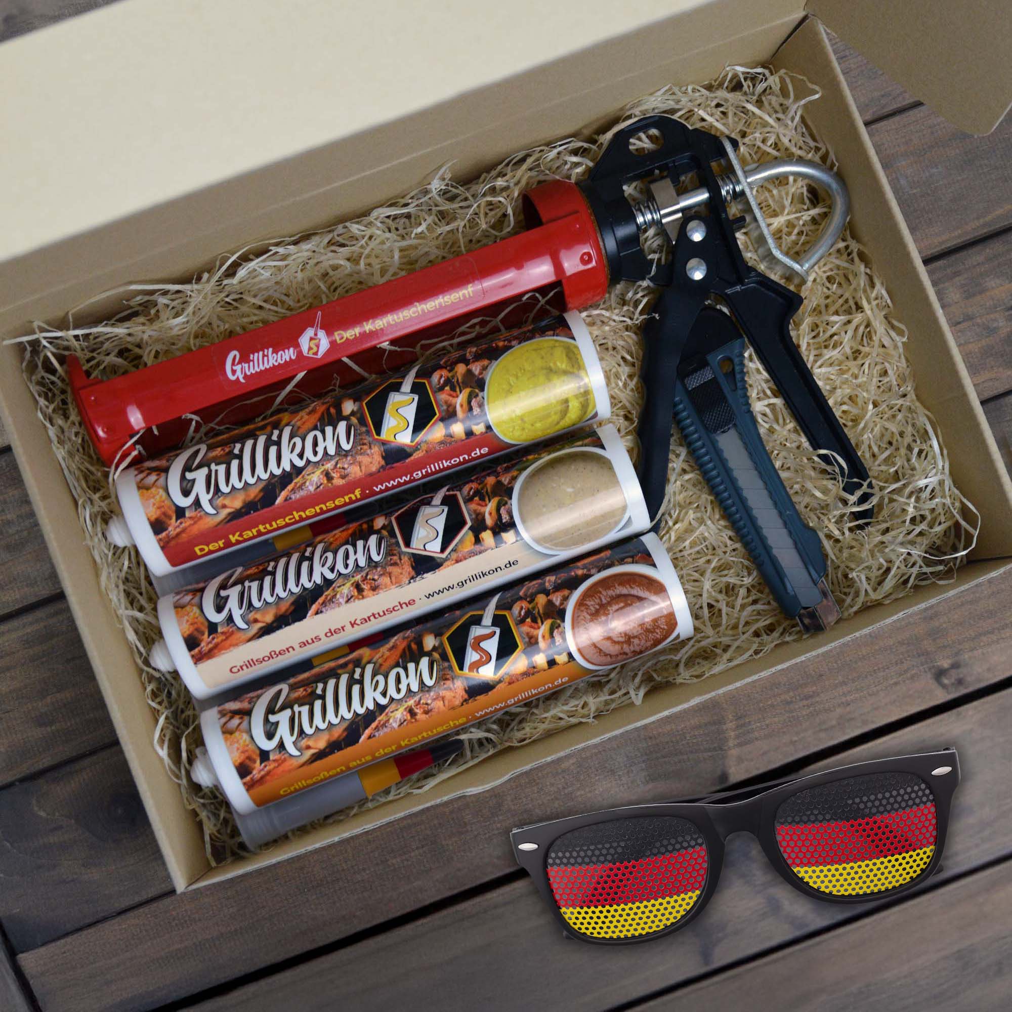 Grillikon Geschenkset „WM-Edition“ mit 3x Mix in 300 ml Kartuschen, Kartuschenpistole, Cuttermesser und Deutschland-Fanbrille im Geschenkkarton mit Holzwolle