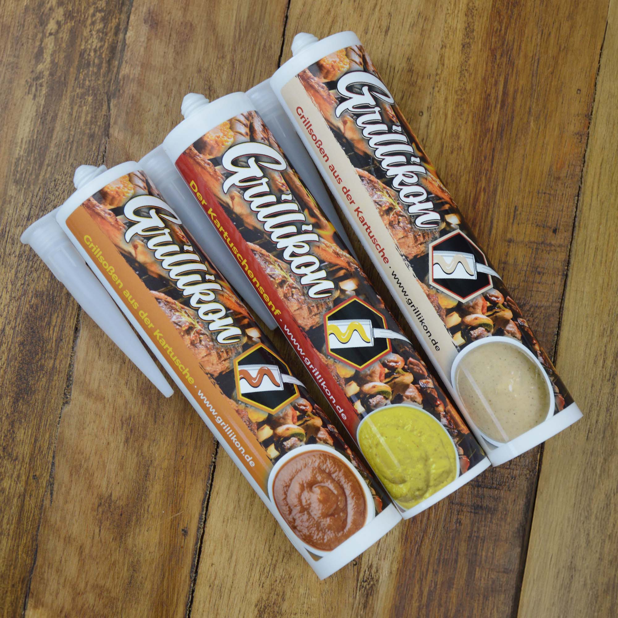 Drei Grillikon Kartuschen mit Grillsaucen und Senf als Grillikon Geschenkset „WM-Edition“ 3x Mix in 300 ml Kartuschen auf Holztisch